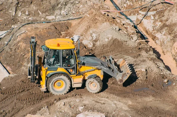 Escavadeira trator com passeios de balde correndo através de terras lama configuração, vista da altura — Fotografia de Stock
