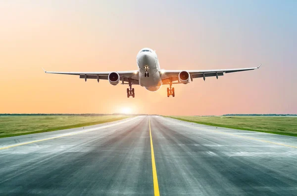 O avião aterrou na pista à noite ao pôr-do-sol no aeroporto . — Fotografia de Stock