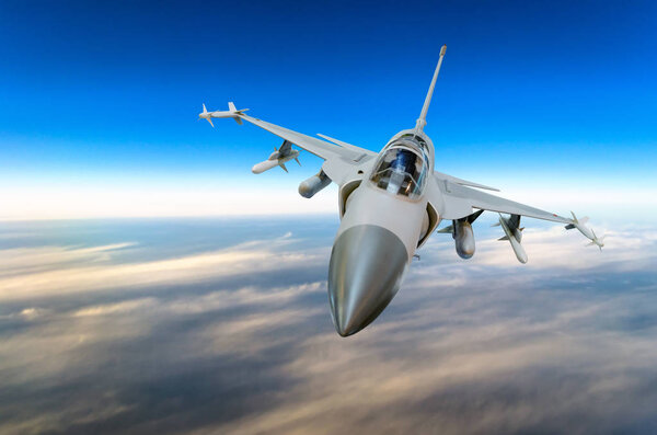 Military fighter jet against a blue sky with a backlight from below.