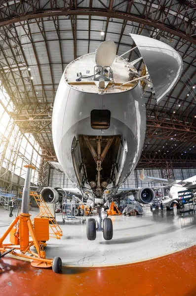 A large passenger aircraft on the service in the aviation hangar view the nose and radar under the hood, the front chassis riser. — Stock Photo, Image