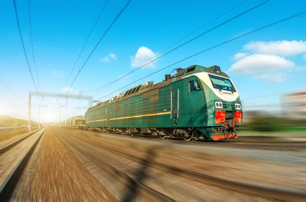 Locomotiva elétrica com um trem de carga em passeios de alta velocidade por estrada ferroviária . — Fotografia de Stock