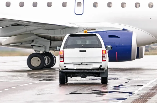 El coche está esperando a que el avión pase por la pista en el aeropuerto . —  Fotos de Stock