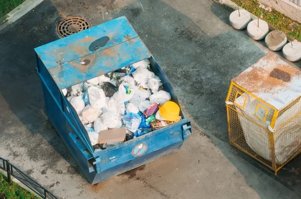 Metal container with garbage household waste, top view.