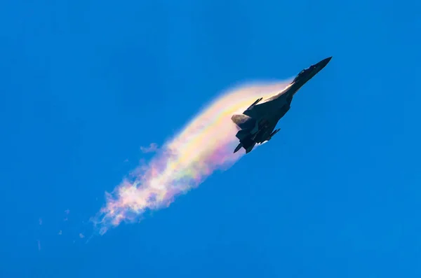Caça de batalha avião a jato mergulha quebrando nuvens em um céu azul . — Fotografia de Stock