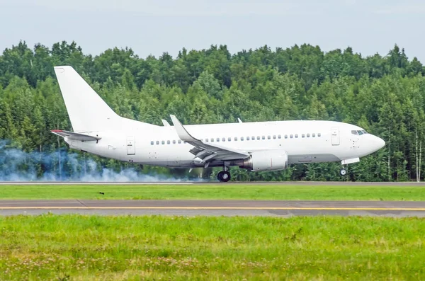 Avión aterrizando en la pista del aeropuerto con humo del chasis. Aterrizaje duro . —  Fotos de Stock