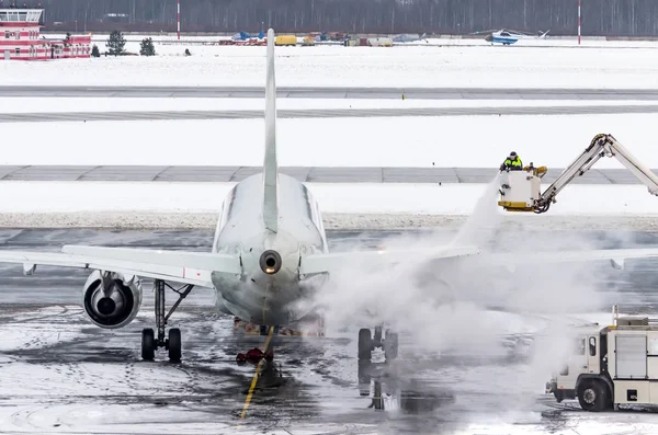 Ground crew provides de-icing. They are spraying the aircraft, which prevents the occurrence of frost. — Stock Photo, Image