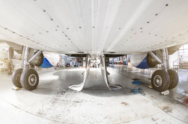 View from under the aircraft between the chassis racks of wheels in the hangar. — Stock Photo, Image