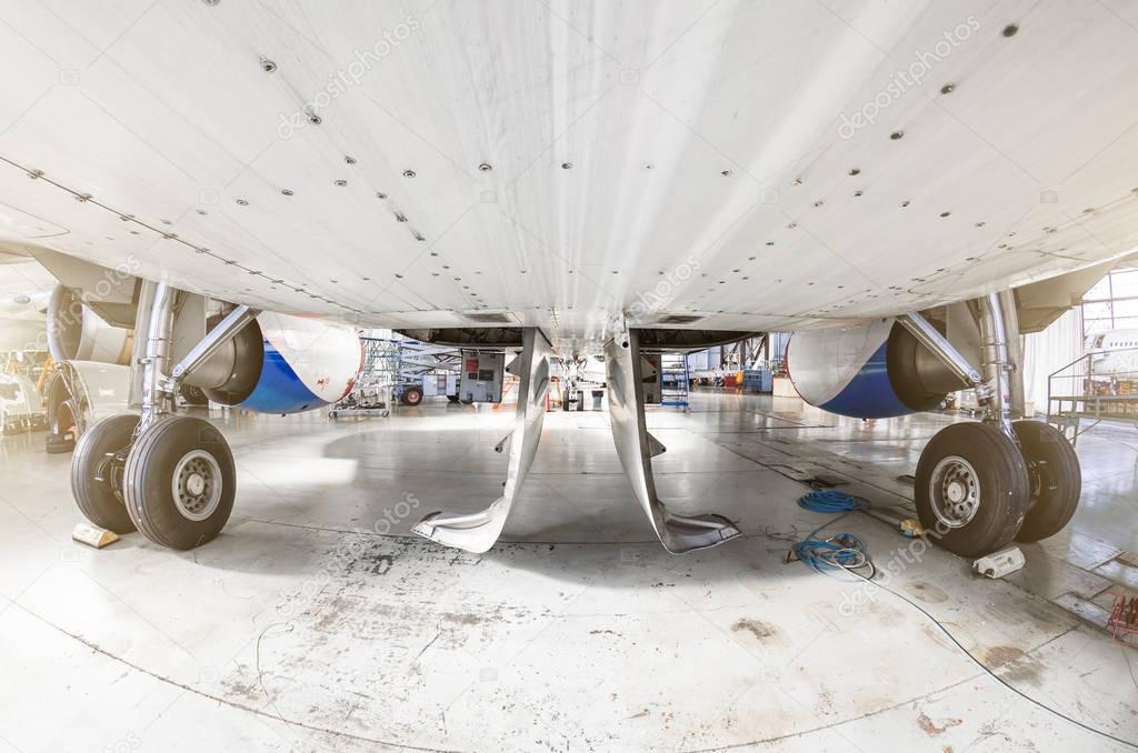 View from under the aircraft between the chassis racks of wheels in the hangar.