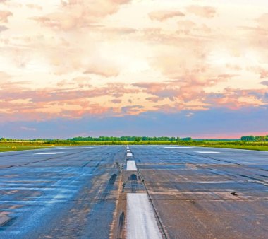 Gün batımında ufukta bir bölen şeridi ile asfalt yol.