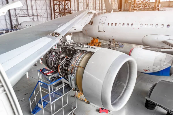 Vista da asa e do motor da reparação da aeronave no hangar . — Fotografia de Stock