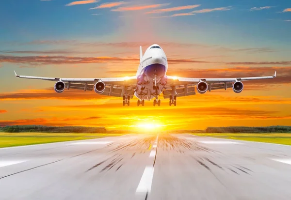 Passagier vliegtuig landing bij zonsondergang op een baan. — Stockfoto