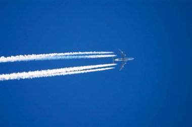 Uçak dört büyük motorları Havacılık Havaalanı contrail bulutlar.