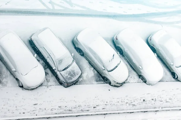 Snötäckt bil på parkeringen. stadsbilden. efter en snöstorm. ren bil från snön. — Stockfoto