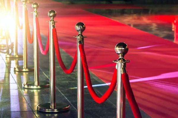 Portable Barrier for Queue Control. Red security rope by red carpet.