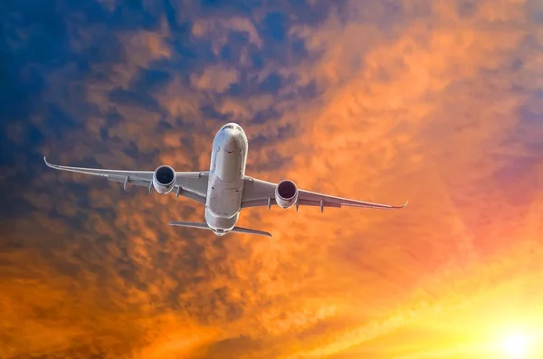 Avión con las luces encendidas después de despegar de la pista al atardecer . — Foto de Stock