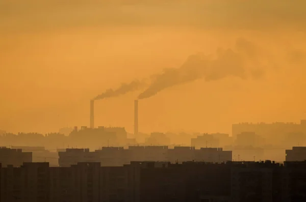 Σωλήνα πόλη με πορτοκαλί καπνού σε χειμωνιάτικο ηλιοβασίλεμα. — Φωτογραφία Αρχείου