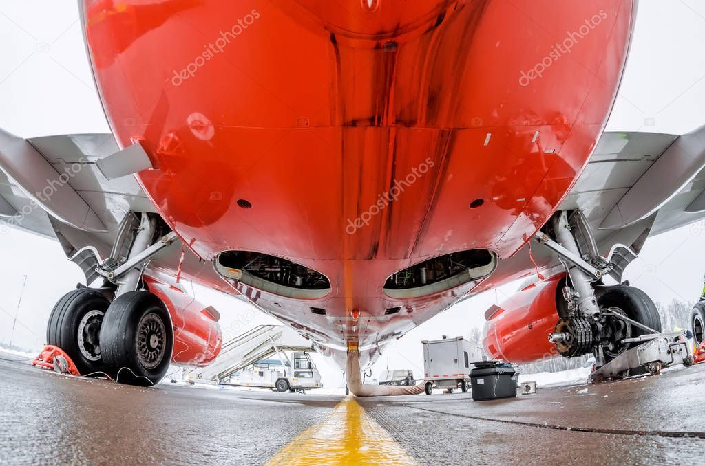 Airplane fuselage and main landing gear repair, bottom view close up.