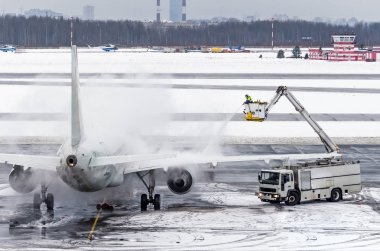 Ground crew provides de icing. They are spraying the aircraft, which prevents the occurrence of frost. clipart