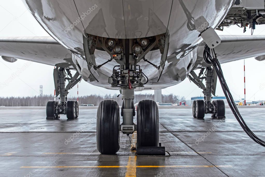 Landing gear and aircraft wheels parked at the airport, with basic power supply.