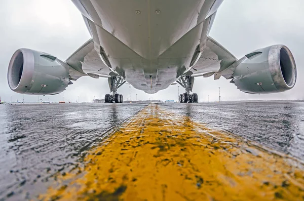 Large passenger aircraft parked at the airport, bottom view, chassis and engines. — Stock Photo, Image