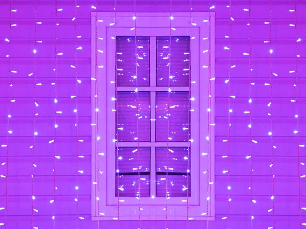 Window of the house decorated with Christmas and Christmas purple lights. — Stock Photo, Image