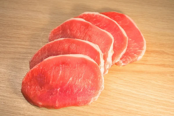 Fünf Stück Schweinefleisch gehackt und als Ventilator auf einem Brett mit Holzstruktur gestapelt. — Stockfoto