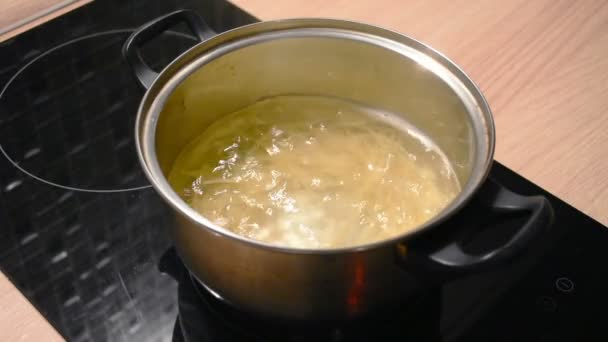 在一个金属锅里煮开水和煮长的意大利面条通心粉在水中 — 图库视频影像