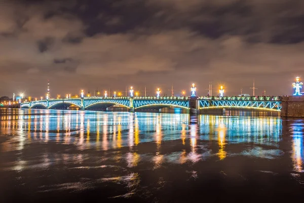 Die Dreifaltigkeitsbrücke Nacht mit Hintergrundbeleuchtung Lichter mit Reflexion in der Neva, Saint-petersburg. — Stockfoto
