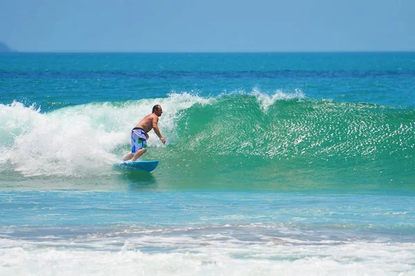 Surfista em azul verde na onda do oceano, a surfar. Indonésia, Bali, 10 de novembro de 2011 . — Fotografia de Stock