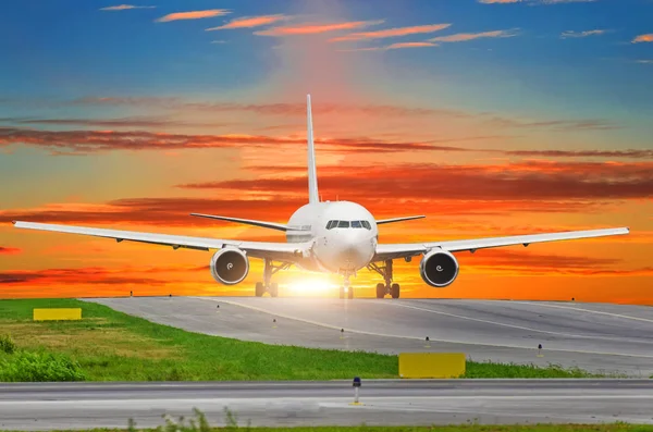 Passagier vliegtuig taxis aan de start-en landingsbaan bij zonsondergang. — Stockfoto