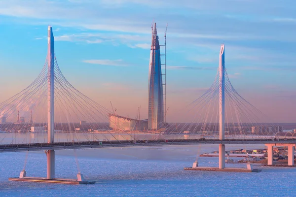 Канатный мост является западным высокоскоростным, а самый высокий небоскреб в Европе - центр Лахты на закате зимой в Санкт-Петербурге. Россия. Санкт-Петербург. 16 января 2018 года . — стоковое фото
