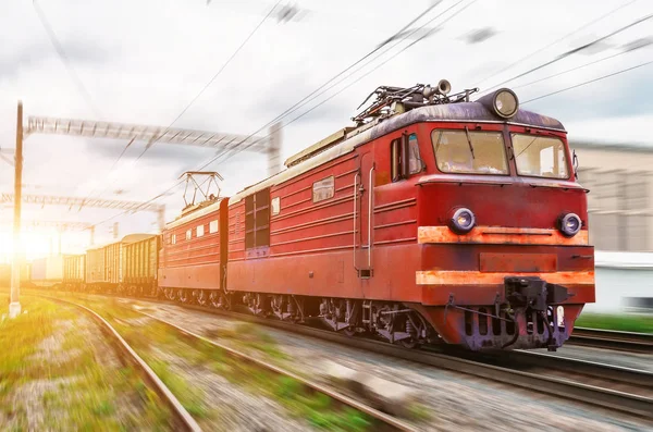 Locomotiva elétrica vermelha com um trem de carga em passeios de alta velocidade de trem . — Fotografia de Stock