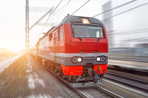 Rode hogesnelheidspassagiersvaartuig trein haasten via het spoor in de avond bij zonsondergang. — Stockfoto