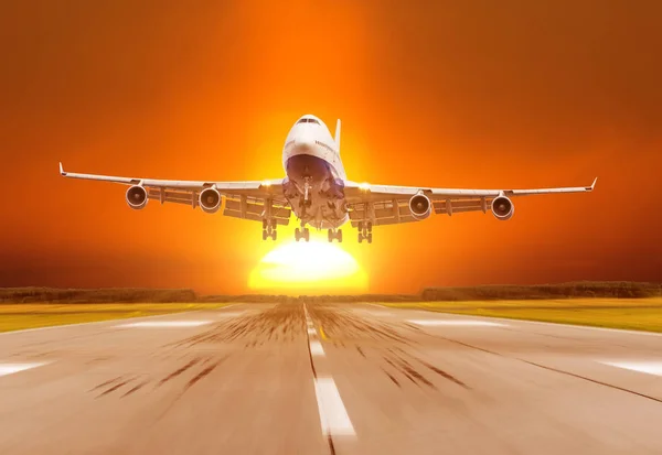Passenger airplane landing at sunset on a runway. — Stock Photo, Image