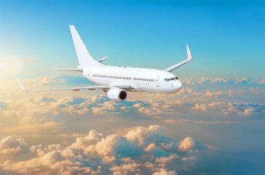 Bulutlar ufuk gökyüzü günbatımı parlak renkleri ile yukarıda uçak uçan.