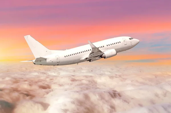 Bulutlar ufuk gökyüzü günbatımı parlak renkleri ile yukarıda uçak uçan. — Stok fotoğraf