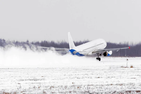 Αεροπλάνο να απογειωθεί από το αεροδρόμιο καλυμμένα με χιόνι διάδρομο σε κακές καιρικές συνθήκες κατά τη διάρκεια μιας χιονοθύελλας, ένας ισχυρός άνεμος το χειμώνα. — Φωτογραφία Αρχείου
