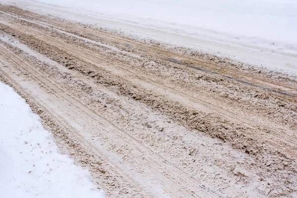 Ośnieżona droga zmieszana z błotem, soli, odczynniki chemiczne oraz śladowe ilości samochodów. — Zdjęcie stockowe