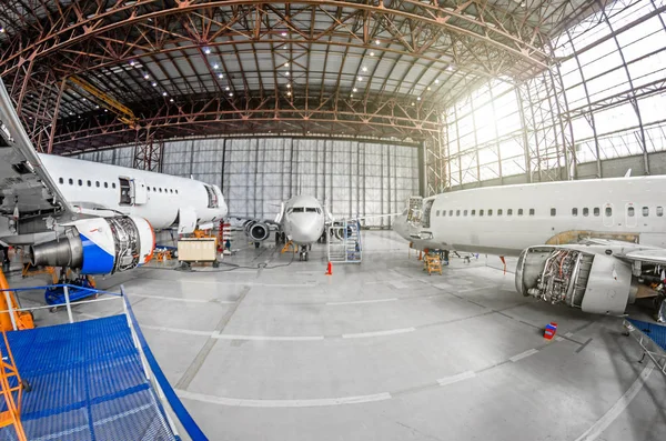Three passenger aircraft on maintenance of engine and fuselage repair in airport hangar. — Stock Photo, Image