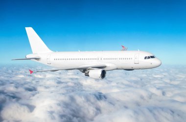 Yolcu uçağı bir trende mavi gökyüzü ve bulutlar üzerinde.