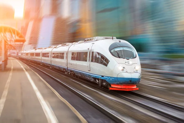 Hochgeschwindigkeitszug fährt mit hoher Geschwindigkeit am Bahnhof in der Stadt. — Stockfoto