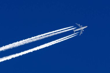 Uçak dört büyük motorları Havacılık Havaalanı contrail bulutlar.