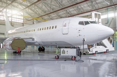 Yolcu uçağı havaalanı hangarında motor ve gövde onarımı üzerine.