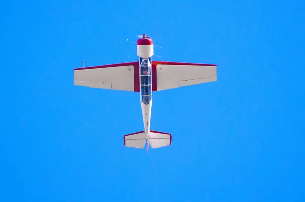 Samolot flys nogami w błękitne niebo. — Zdjęcie stockowe