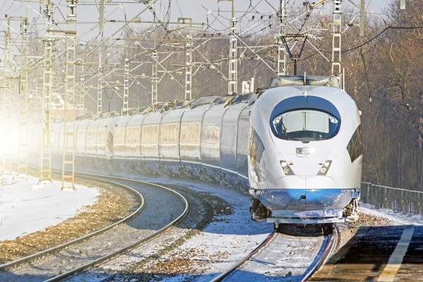 Comboio de alta velocidade monta muito tempo na curva em alta velocidade na estação ferroviária da cidade . — Fotografia de Stock