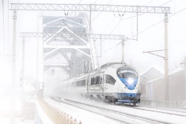 Passeios de trem de alta velocidade na ponte ferroviária de metal de alta velocidade no inverno em torno da paisagem nevada . — Fotografia de Stock