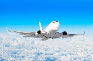 Beyaz uçak tırmanıyor yüksekliği, uçuş seviyesi yüksek bulutlar mavi gökyüzü yukarıda gökyüzünde uçar.