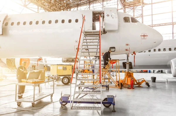 Las aeronaves están en reparación, la inspección técnica es un técnico de trabajo. Una vista de la nariz, una cabina de pilotos con una escalera que conduce a la entrada . —  Fotos de Stock