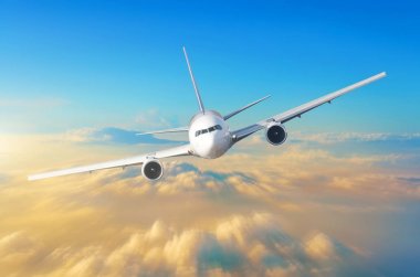 Gökyüzünde bulutlar ve turuncu günbatımı yukarıda yüksek hızlı yolcu uçak uçar, pilotlar kokpit tam olarak görünümdür.