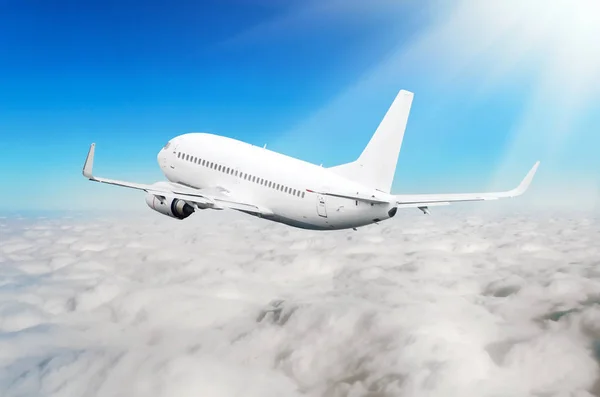 Bílé letadlo je stoupání letové výšky, dole je zatažený mraky. — Stock fotografie